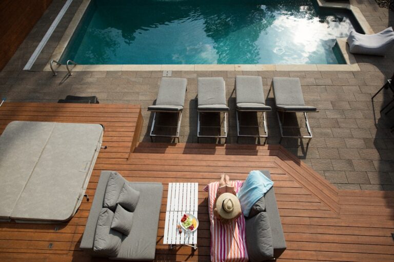 A backyard deck with mixed sunlight and shade, showing a family walking barefoot on smooth boards.