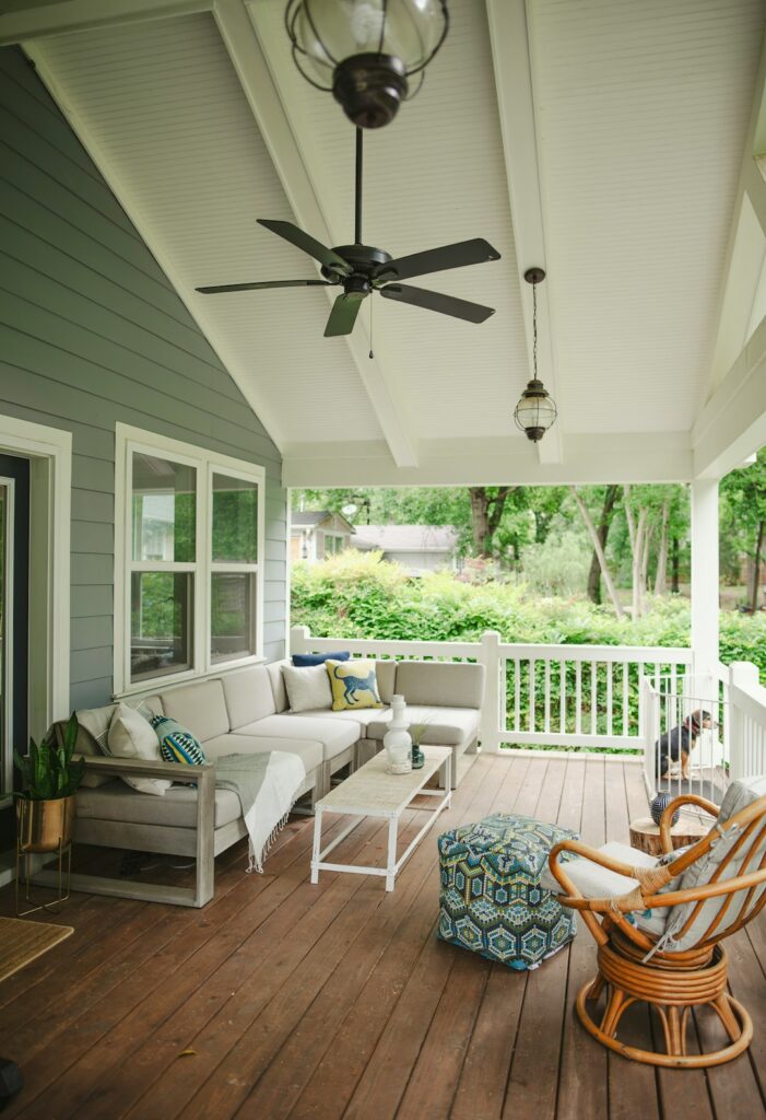 Covered patio with ceiling fan, screened sides, outdoor seating, cushions, and a dry paved floor